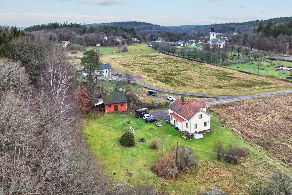 Äldre hus och lada med stor gräsmatta runt om