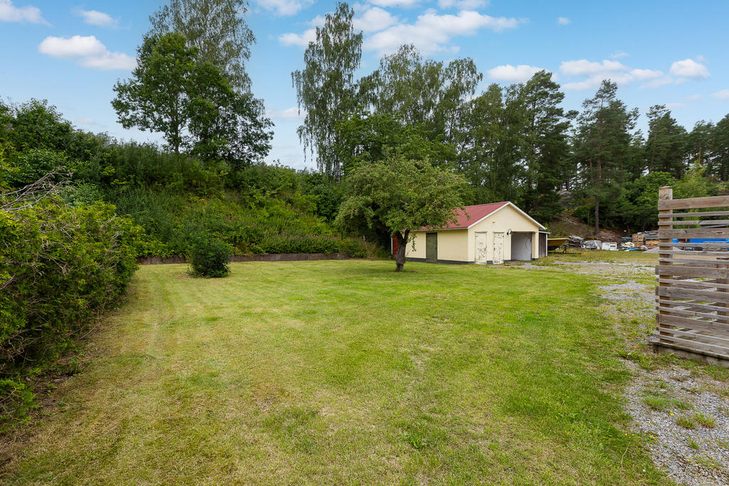 På baksidan finns en garagebyggnad med tillhörande förråd