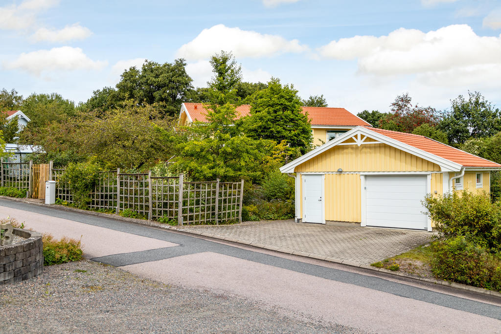 Stor stensatt uppfart framför garage/förråd