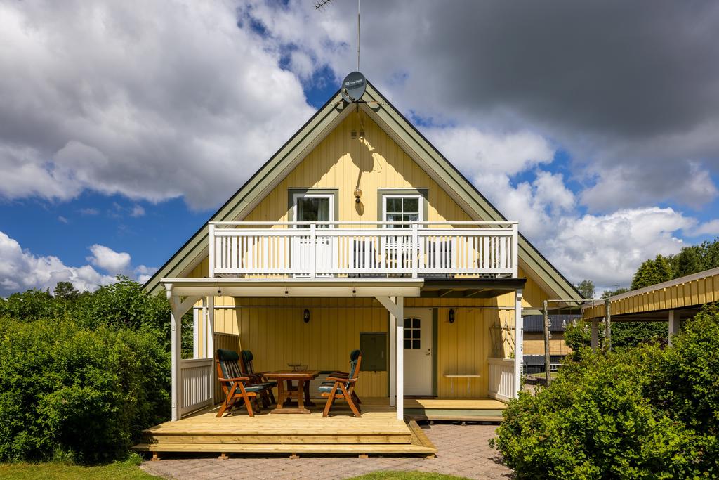 Gaveln med altan samt balkong. Stenlagda gångar mot carport och bastu.