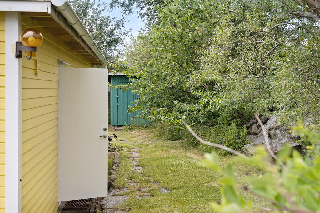 På baksidan om huset finns en groventré ut till trädgården...