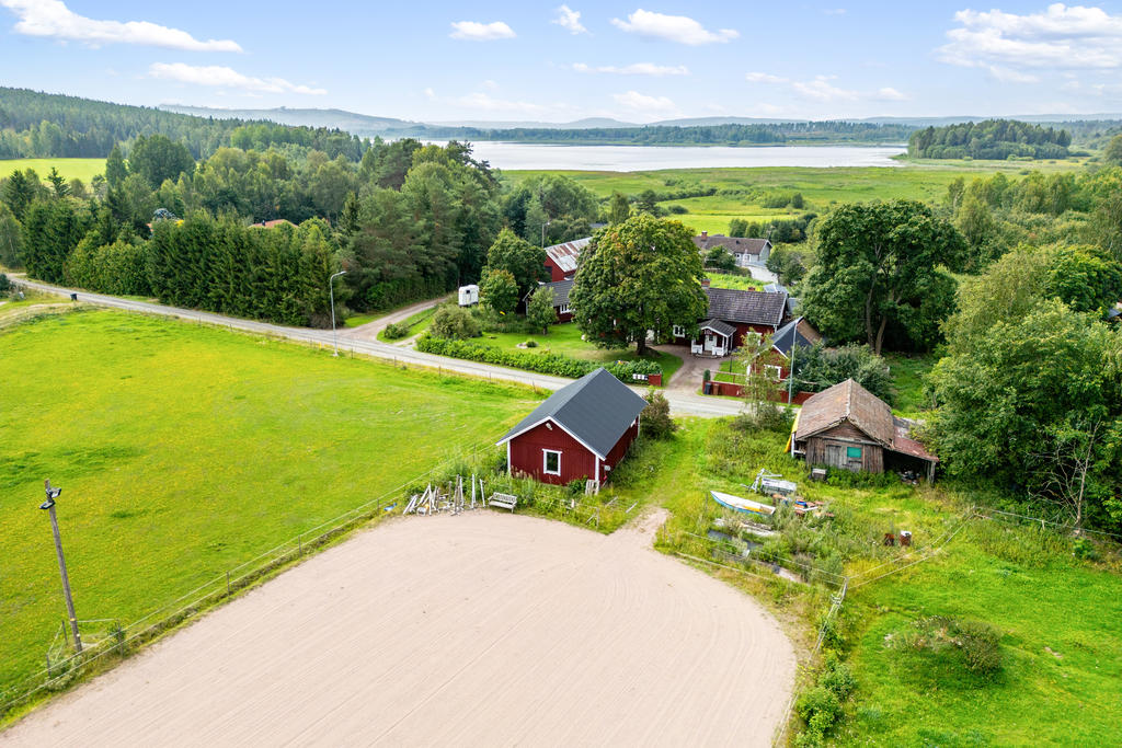 Hela fastigheten med hage och sjön i bakgrunden.