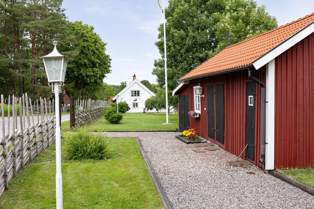 Uthus/garage med huset i bakgrunden