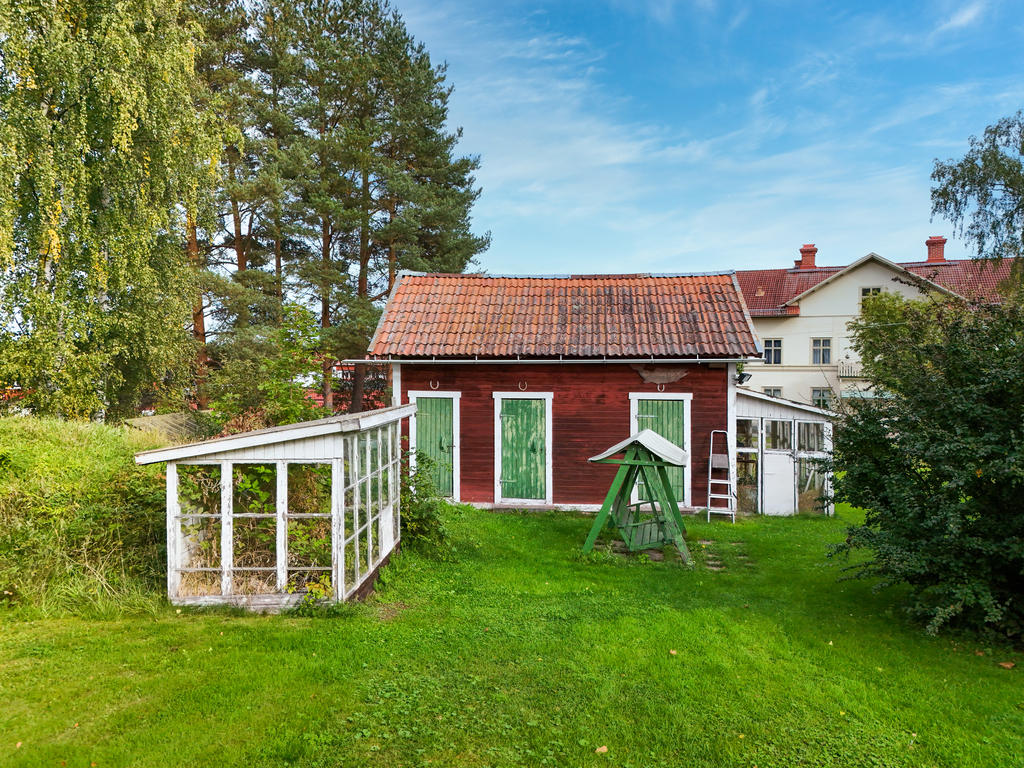 Uthus och växthus beläget på tomtens baksida. 