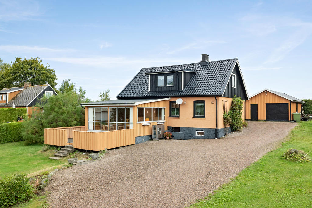 Vackert hus med uterum som öppnar upp mot ett trädäck.