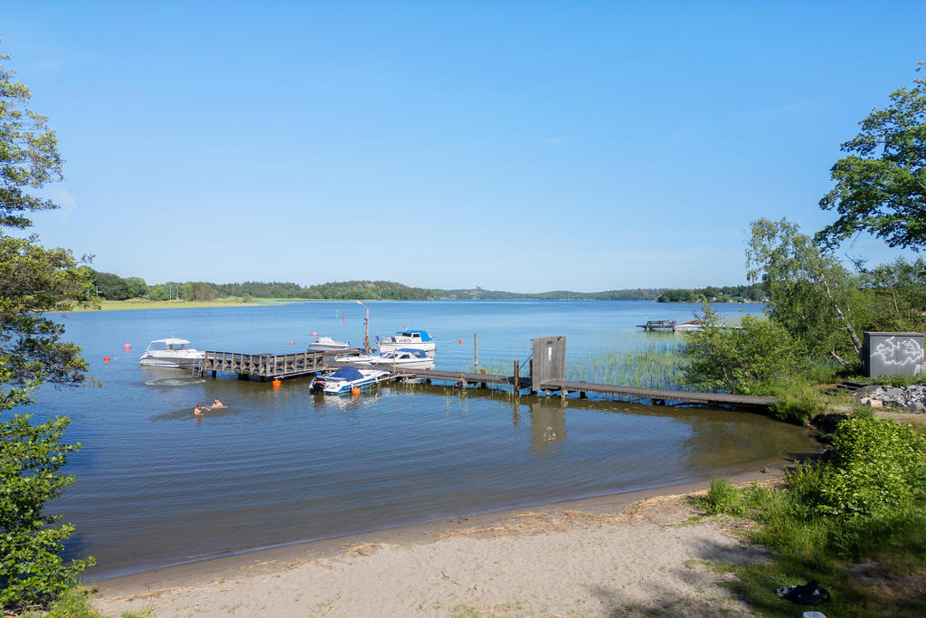 Småbåtshamn och sandstrand ett stenkast från huset