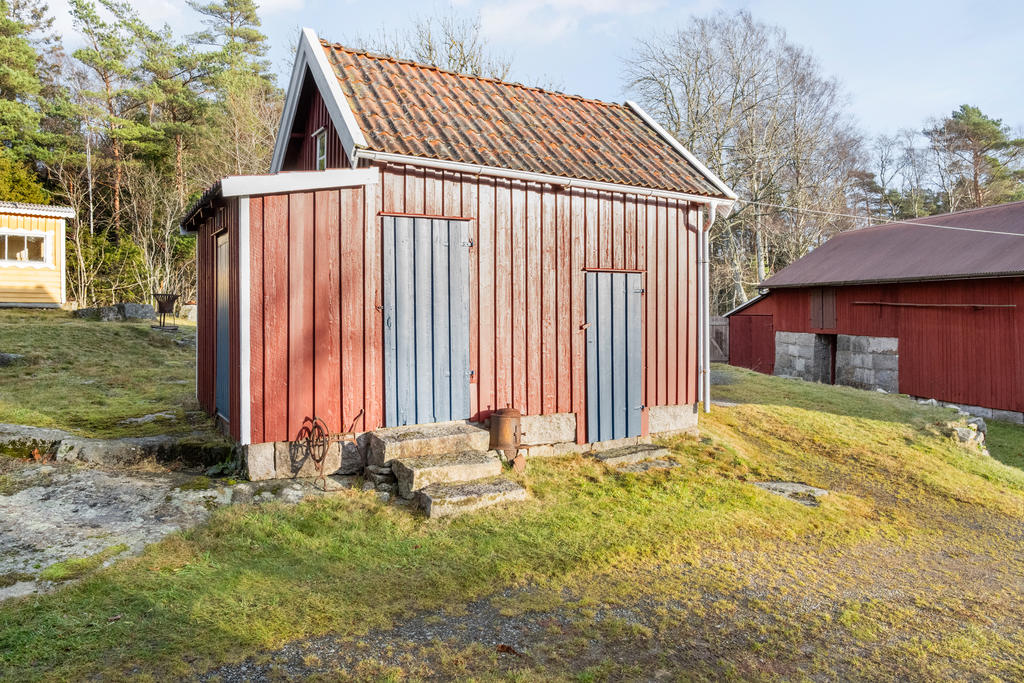 Uthus med vedförråd och plats för förvaring.