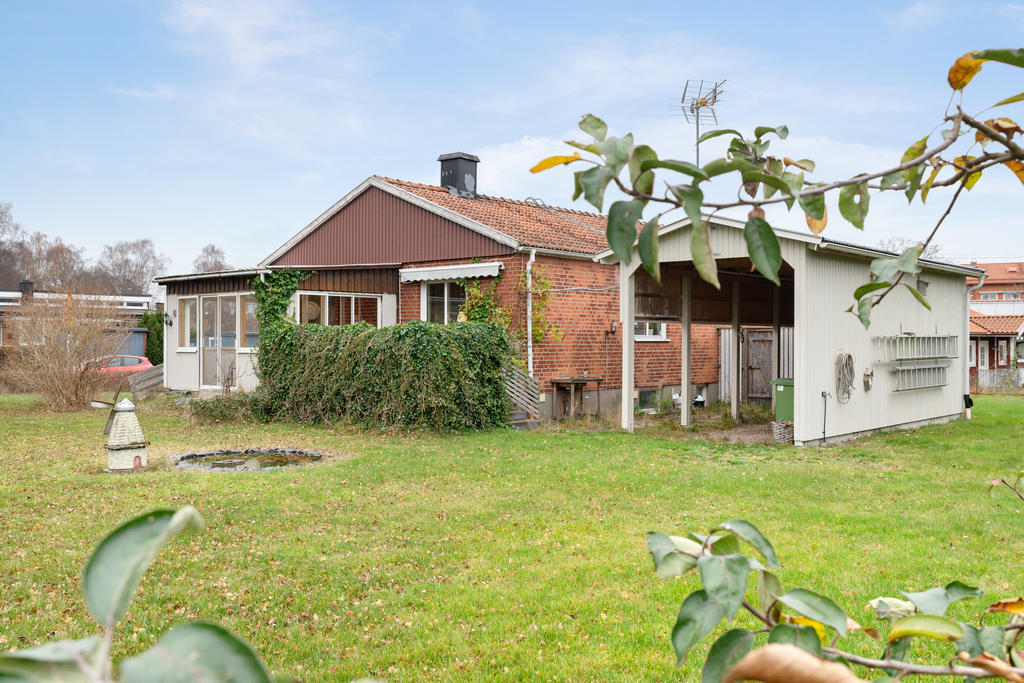 Trädgården på baksidan med uterum och carport