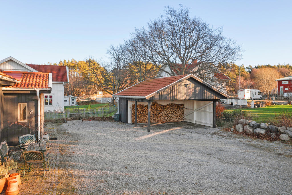 Här finns en praktisk carport med tillhörande förråd, perfekt för smart förvaring. Dessutom erbjuds möjligheter för vedförvaring.