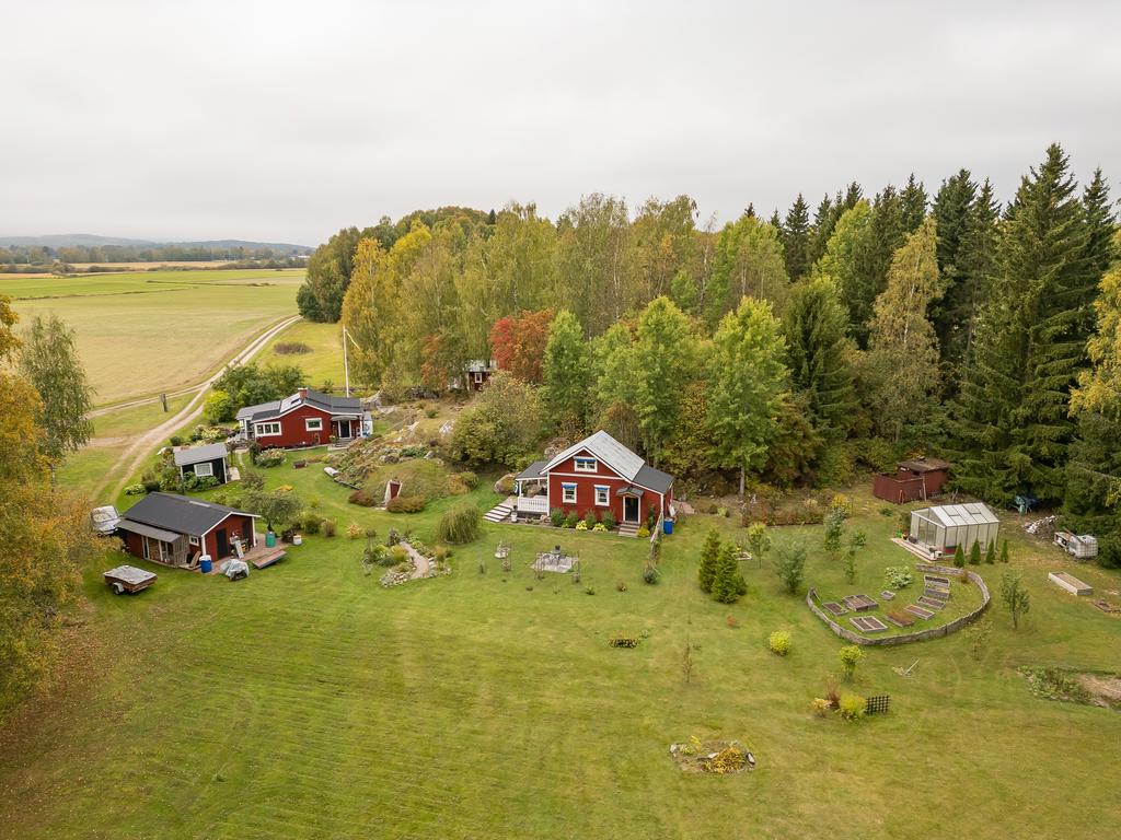 Drönarbild över fastighetens byggnader. Huvudstugan uppe till vänster är välrenoverad och i mycket fint skick.